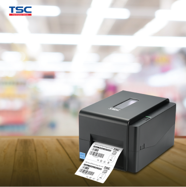 TSC label printer on a wooden surface with a blurred store background