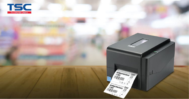 TSC label printer on a wooden surface with a blurred store background